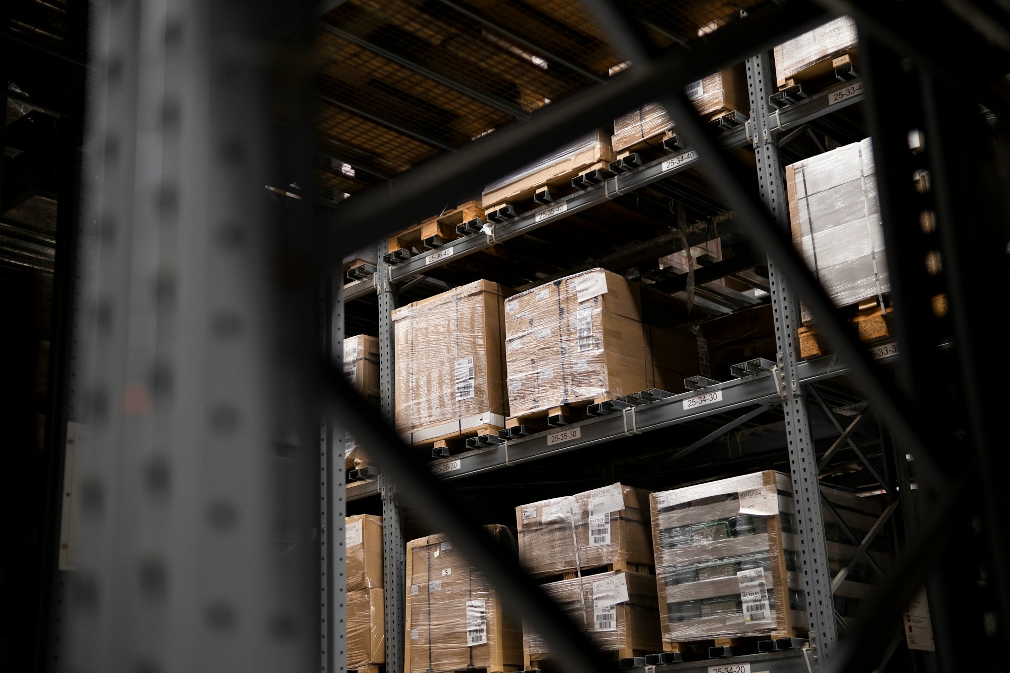 Cardboard boxes and pallets stacked in a fulfilment warehouse